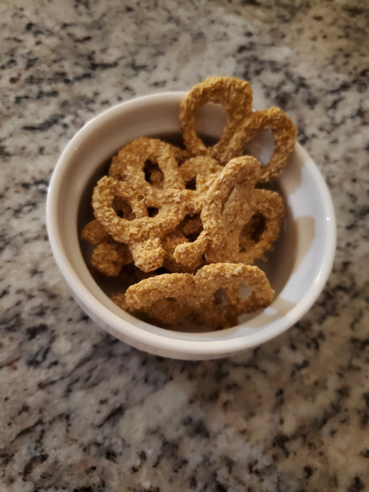 Dog treats in a white bowl on a granite countertop