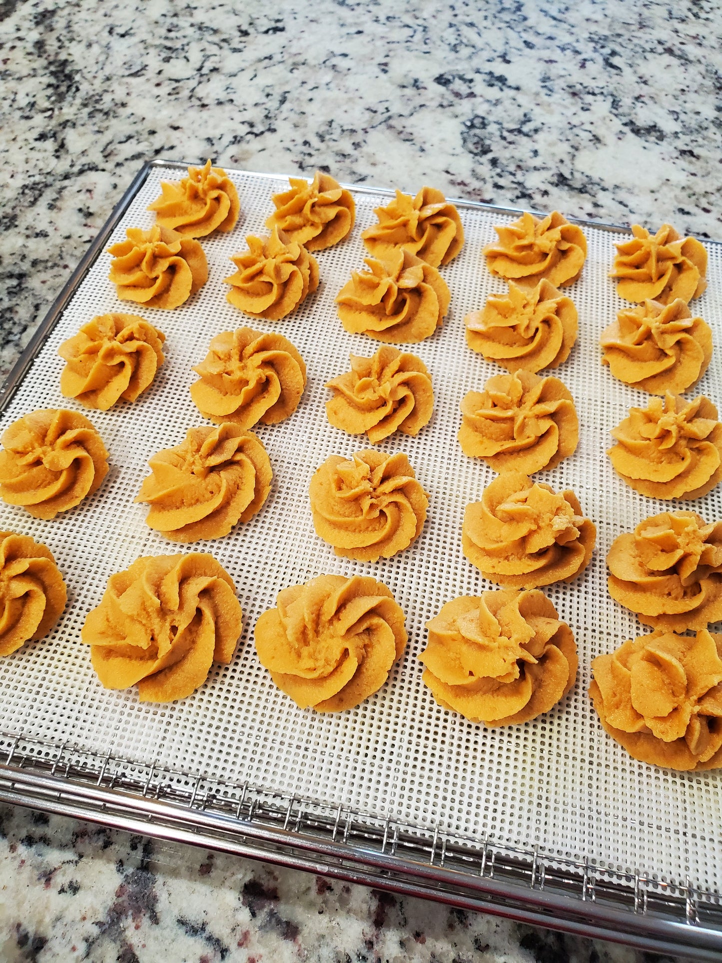 Decorative treats on a cooling rack with a marble countertop background