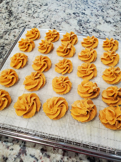 Decorative treats on a cooling rack with a marble countertop background