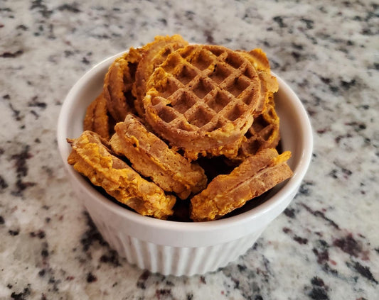 Waffle shaped dog treats in white dish on counter top