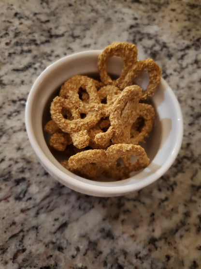Dog treats in a white bowl on a granite countertop