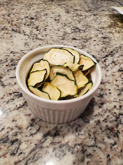 Sliced zucchini in a white ramekin on a granite countertop