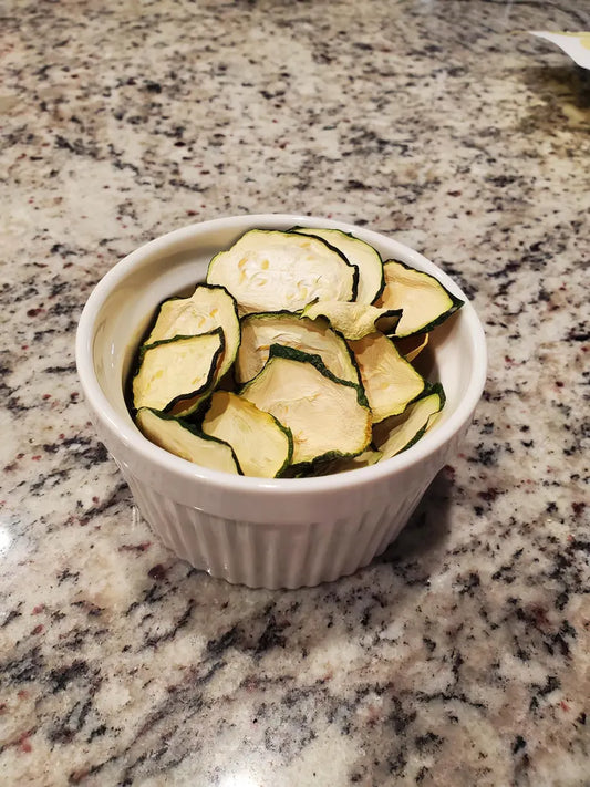 Sliced zucchini in a white ramekin on a granite countertop