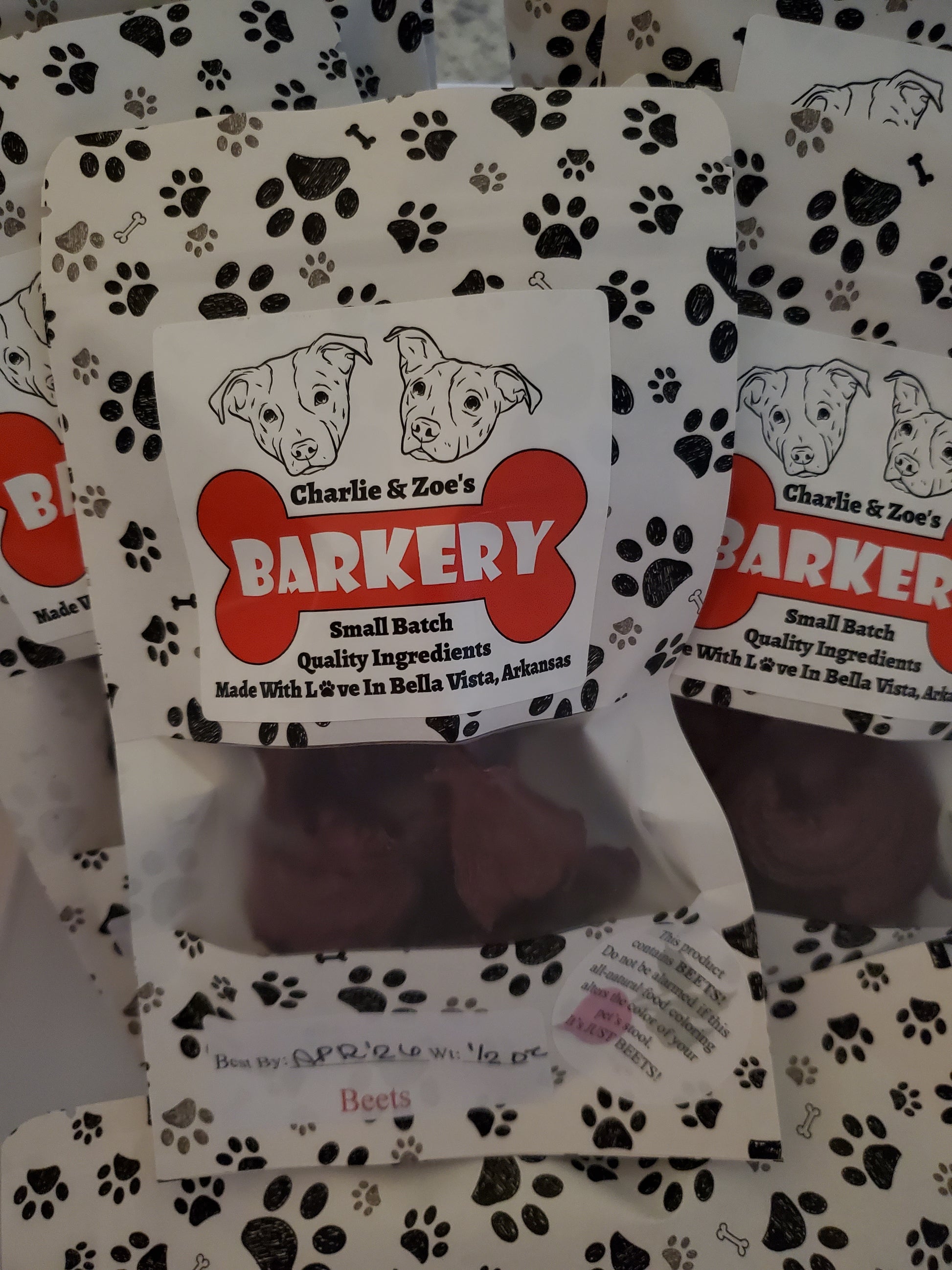 Dog treat packaging with Charlie & Zoe's Barkery branding on a patterned background