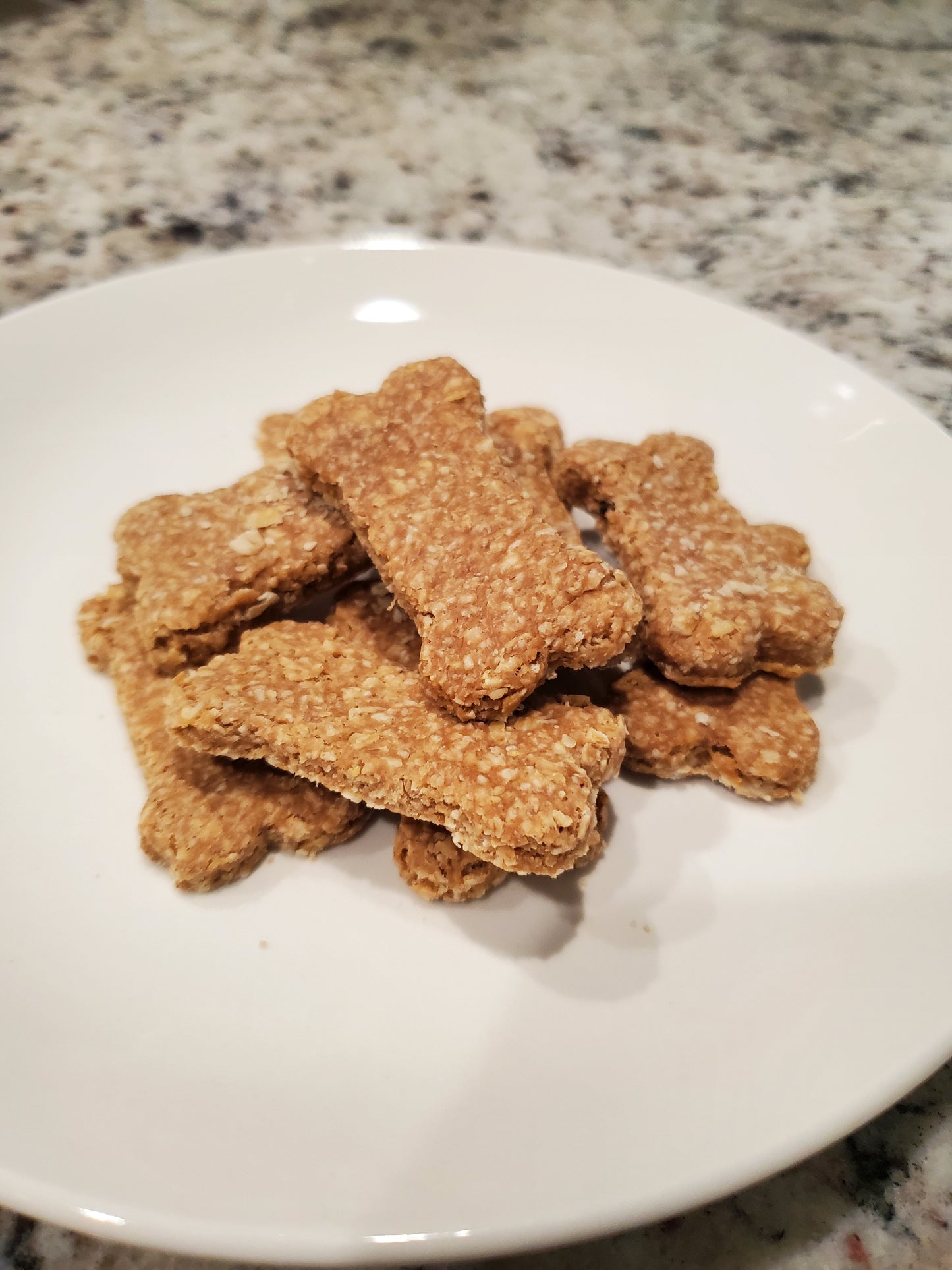 Dog treats shaped like bones on a white plate