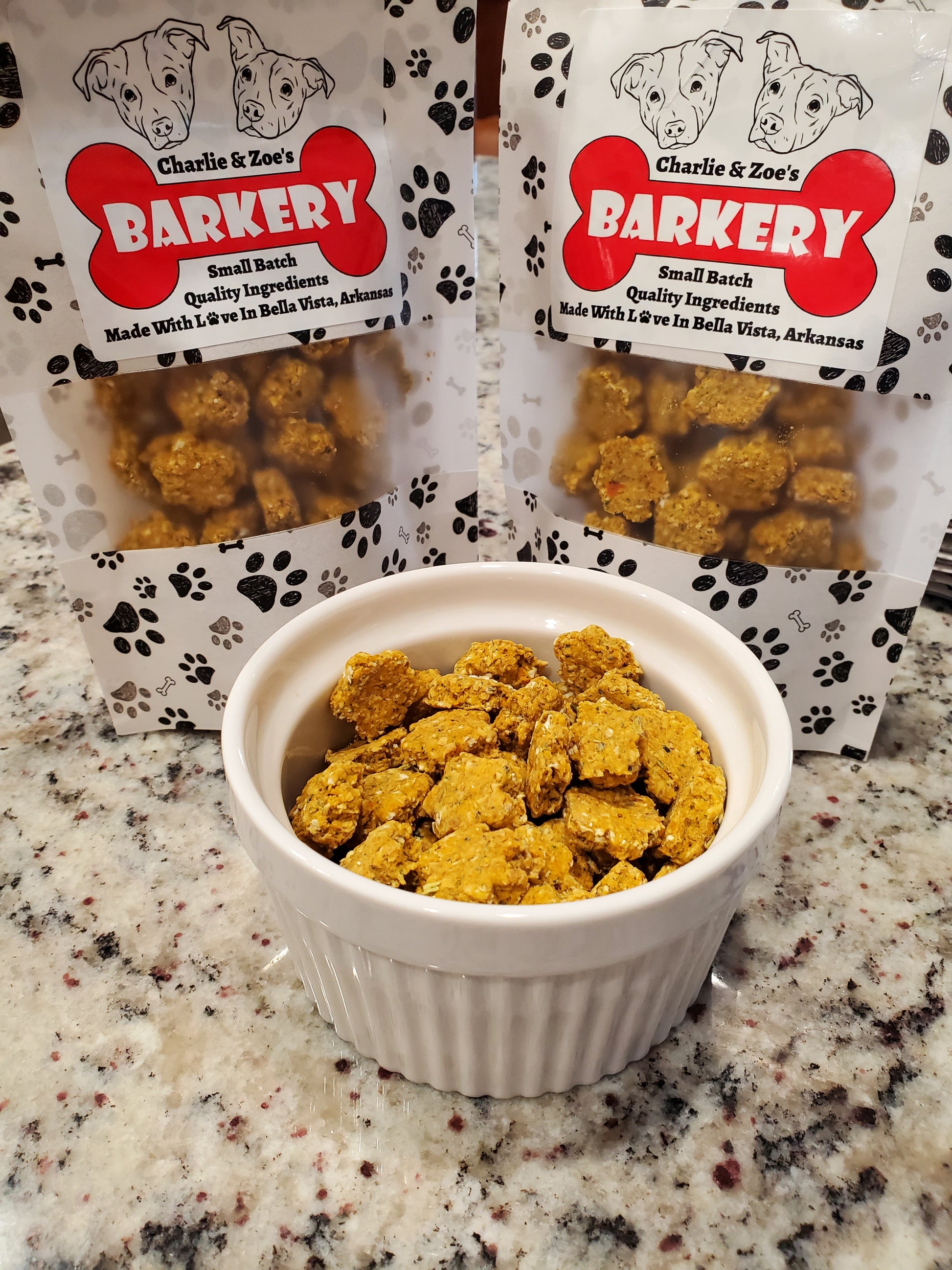 Bowl of cat treats next to Charlie & Zoe's Barkery  packaging on a granite countertop