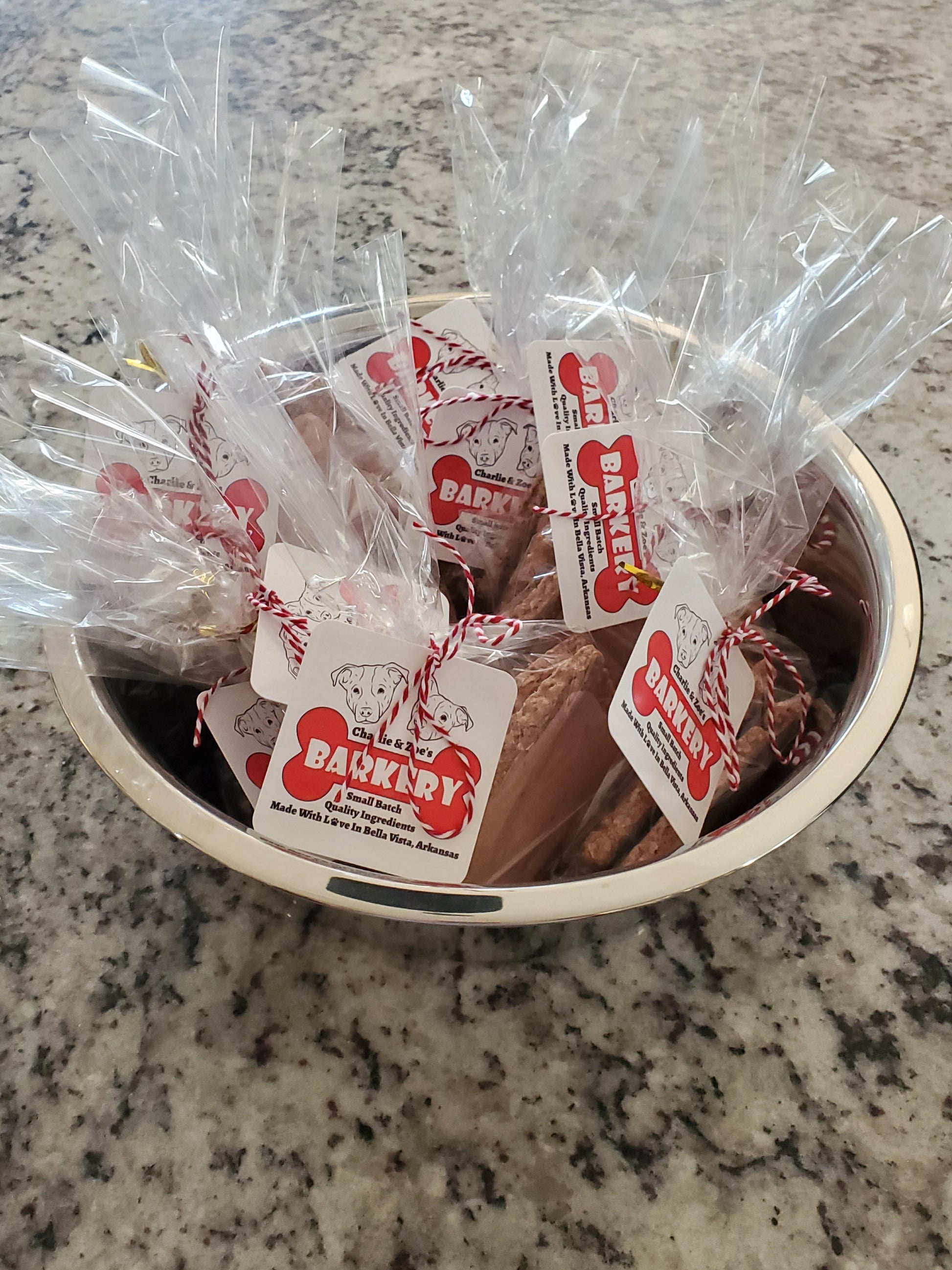 Bowl with dog treats and a plastic bag on a granite countertop